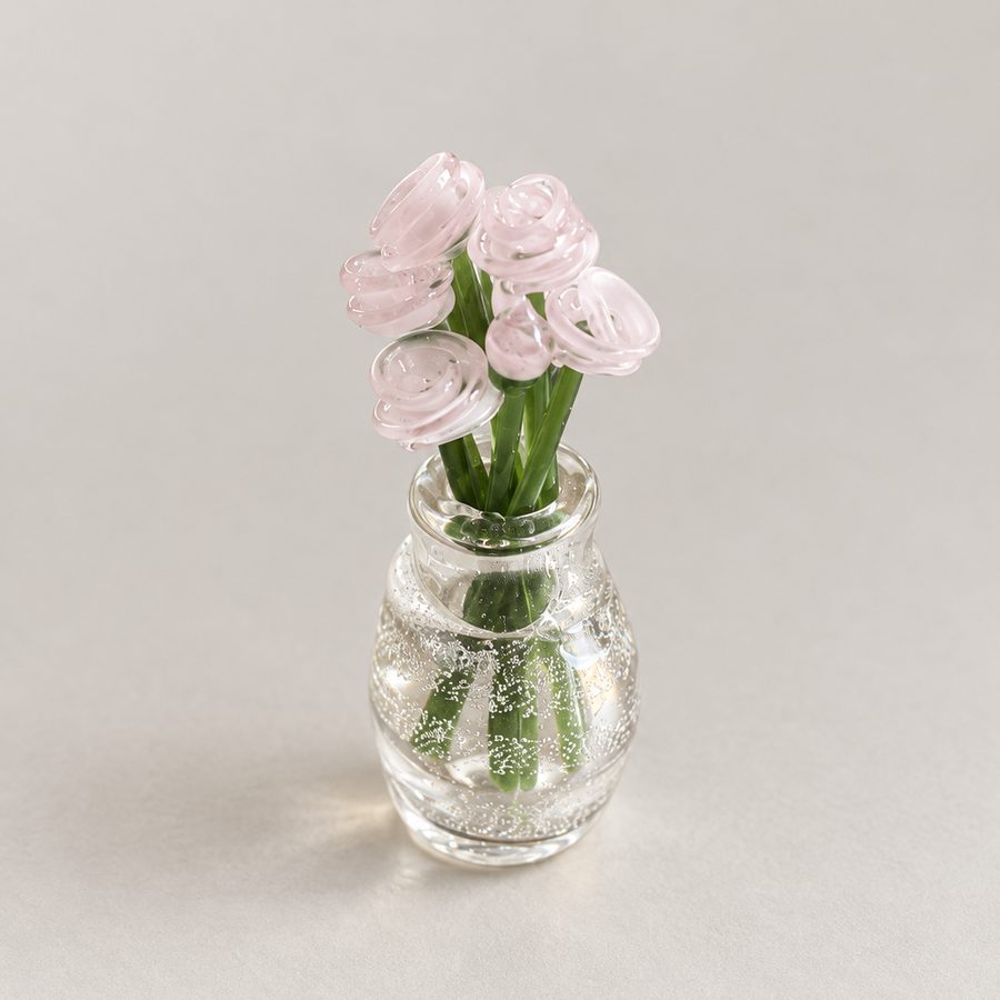 Blush pink glass flowers in a small clear bubble vase