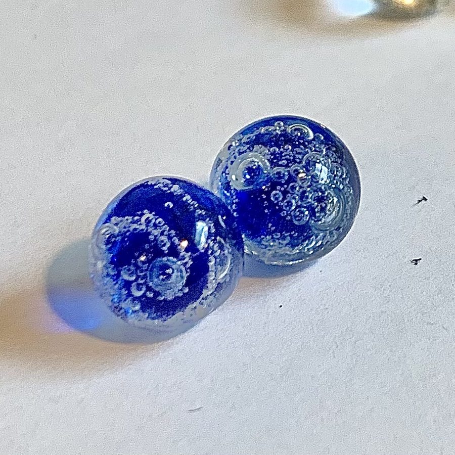 Two cobalt blue glass marbles full of tiny bubbles